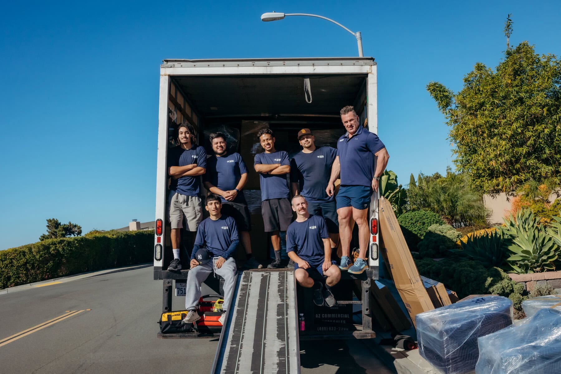 Professional movers sitting in the back of a moving truck after a successful relocation.