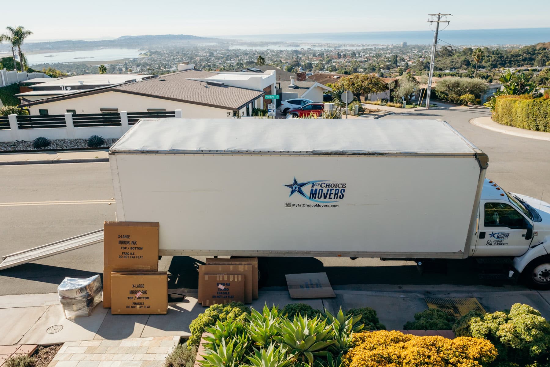 White 1st Choice Movers storage container and moving boxes at a job site.