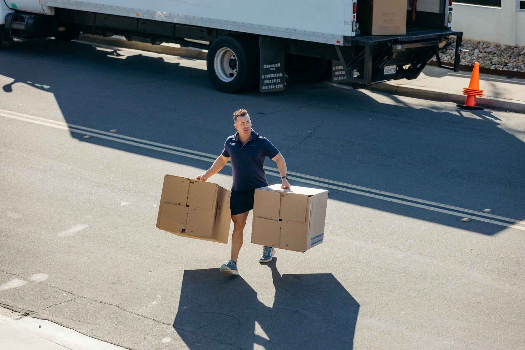 Moving professionals carrying a heavy box during a house move in Miramar, CA.